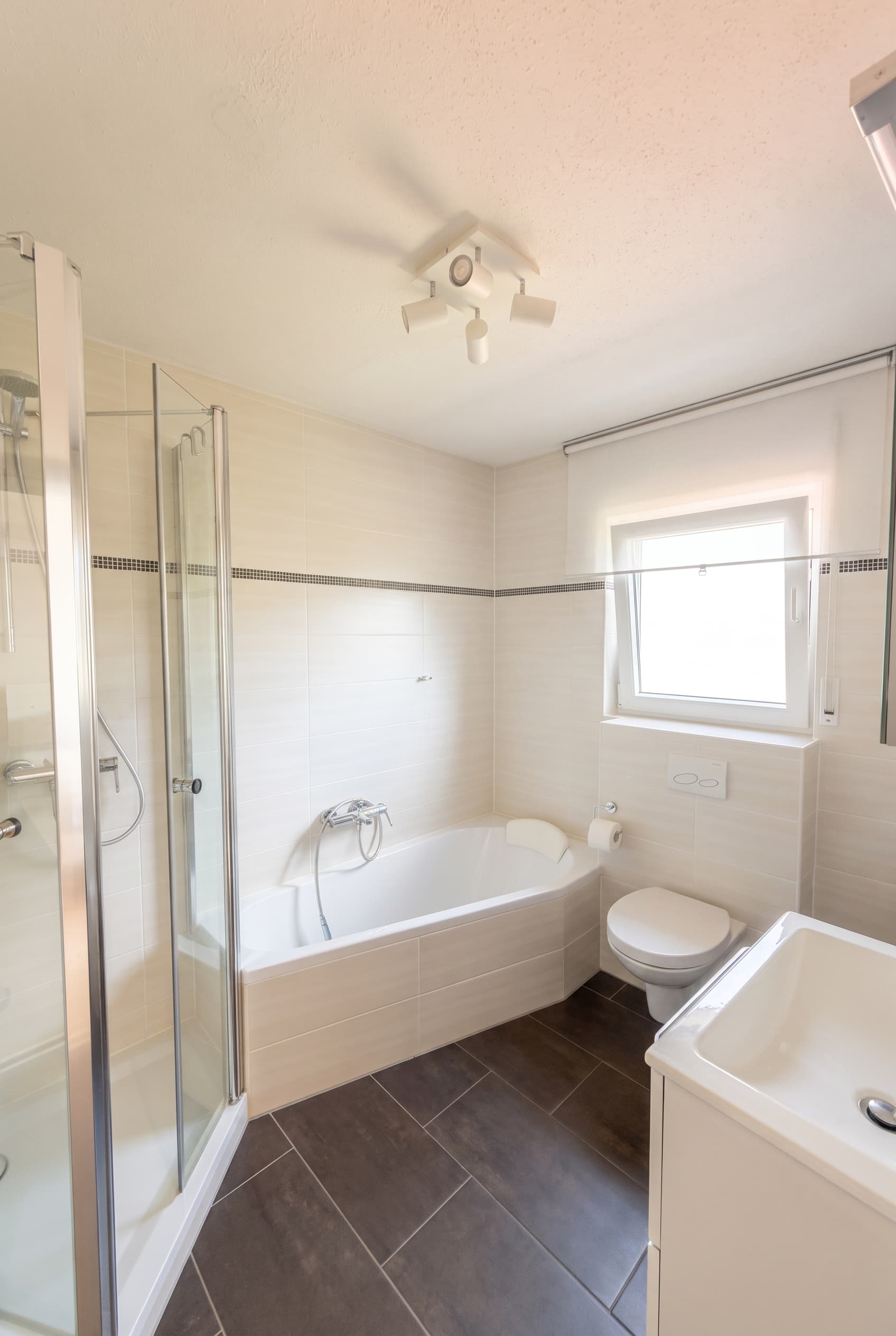Das Bad der renovierten Einheit – Wanne und separate Dusche.