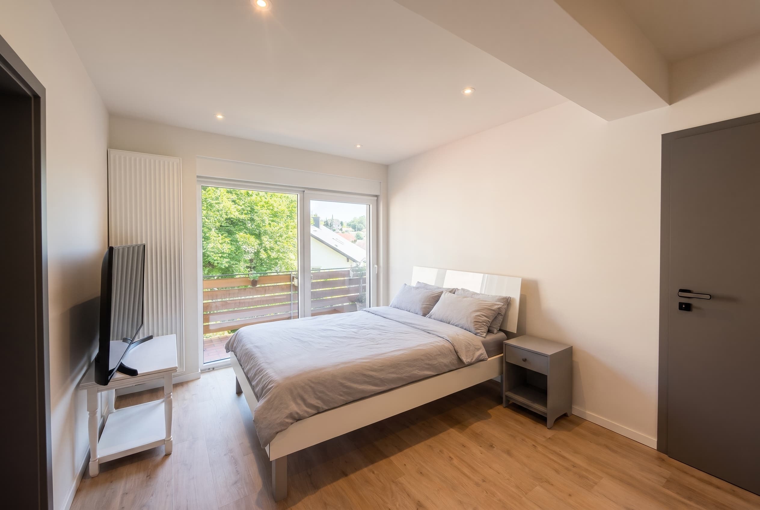 Das Schlafzimmer der renovierten Einheit – Glasfront mit Schiebetür.